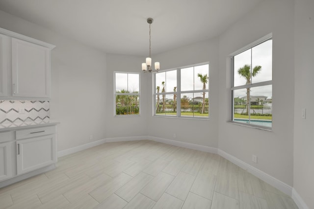 unfurnished dining area with a chandelier and plenty of natural light