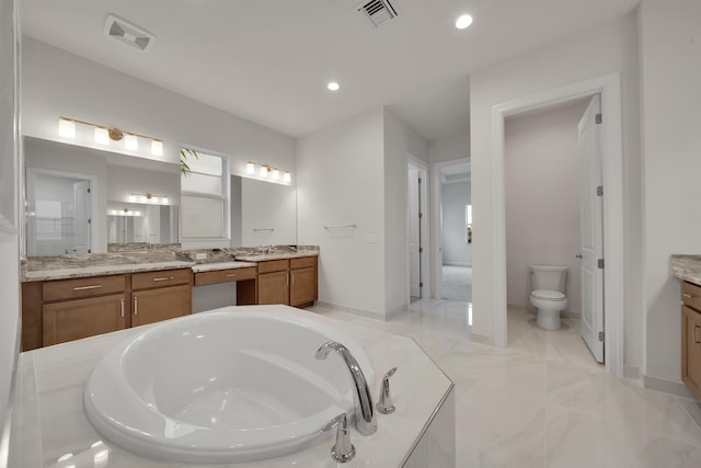 bathroom with vanity, toilet, and a bathing tub