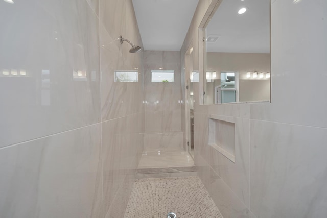 bathroom with tile walls and tiled shower