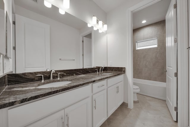 bathroom with toilet, vanity, and tile patterned floors