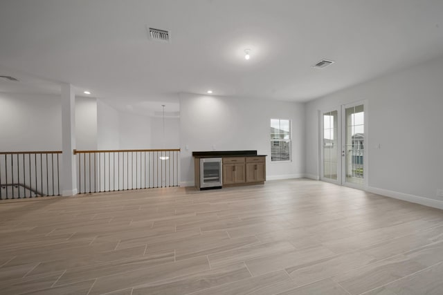 empty room featuring light hardwood / wood-style floors and beverage cooler