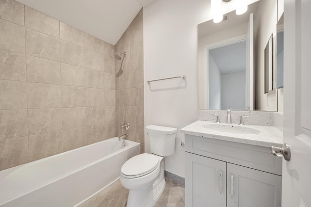 full bathroom featuring tiled shower / bath, vaulted ceiling, toilet, vanity, and tile patterned floors