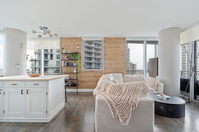 interior space featuring wood walls, open floor plan, dark wood-style flooring, and white cabinetry