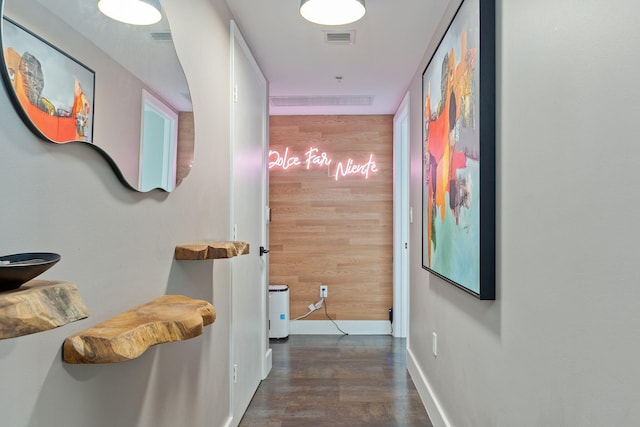 corridor with baseboards, wood finished floors, and visible vents