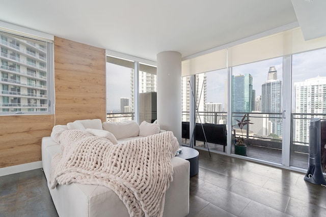 living room featuring a view of city, wooden walls, and a wall of windows