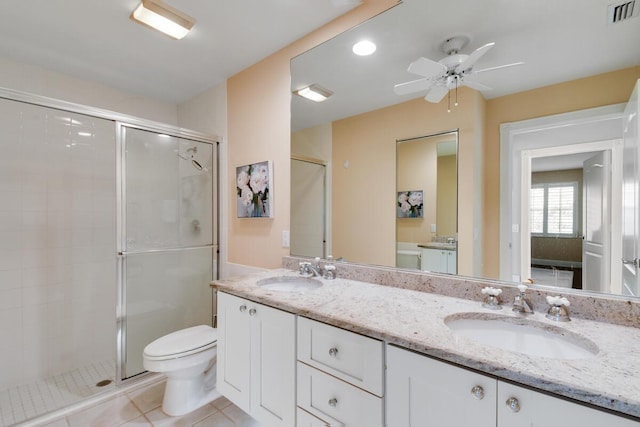 bathroom featuring tile patterned flooring, vanity, toilet, and walk in shower