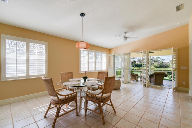 dining room featuring light tile patterned floors, vaulted ceiling, plenty of natural light, and ceiling fan