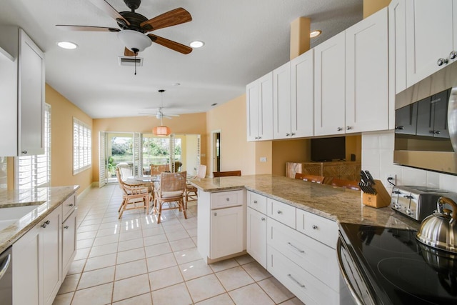 kitchen with white cabinetry, light stone counters, kitchen peninsula, and stainless steel appliances