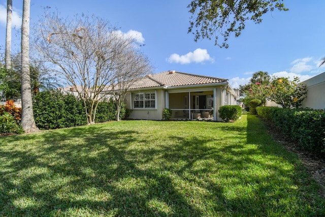 back of house with a sunroom and a lawn