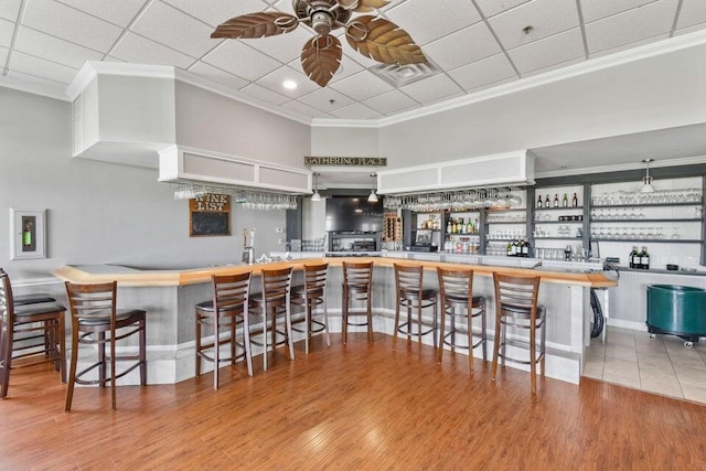 kitchen featuring a kitchen breakfast bar, kitchen peninsula, and ornamental molding