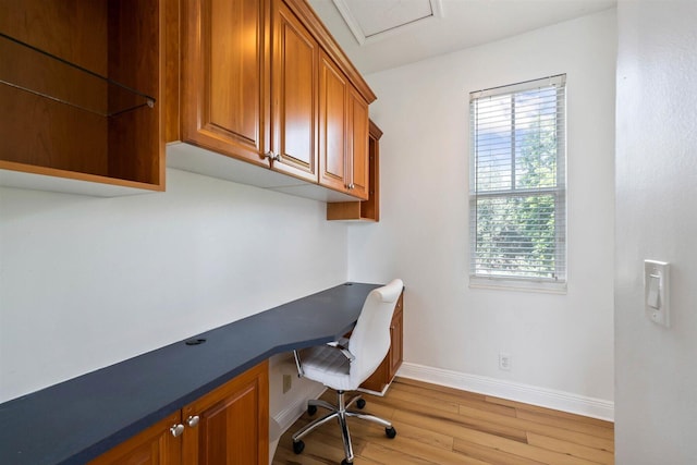 home office featuring built in desk and light hardwood / wood-style flooring