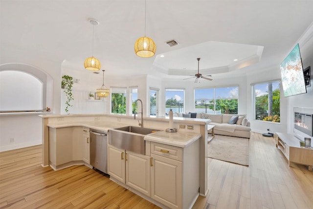 kitchen featuring dishwasher, light hardwood / wood-style flooring, and an island with sink