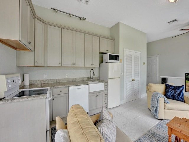 kitchen featuring sink, white appliances, and track lighting