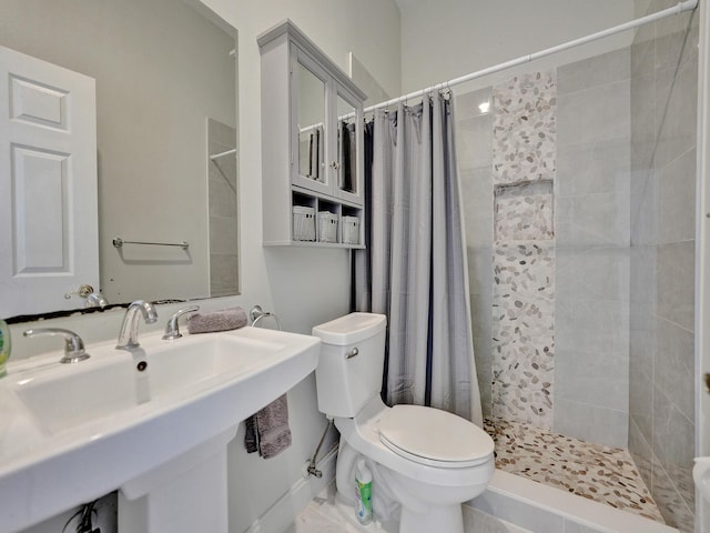 bathroom featuring toilet, sink, and a shower with curtain