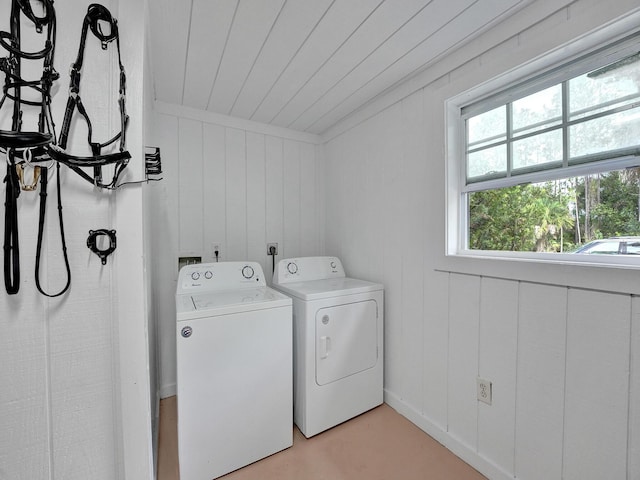 washroom with wooden walls, wooden ceiling, and washing machine and clothes dryer