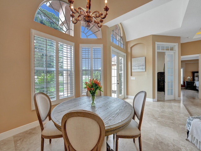 dining area featuring a wealth of natural light, a notable chandelier, and french doors