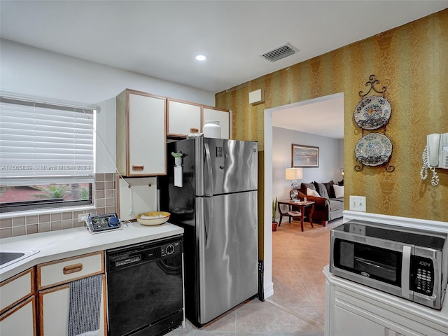 kitchen featuring white cabinets, stainless steel appliances, and light tile patterned floors