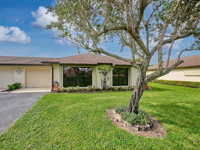 ranch-style home featuring a front lawn and a garage