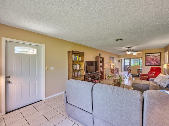 tiled living room featuring ceiling fan and a textured ceiling