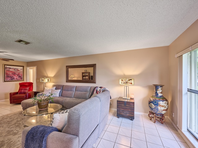 tiled living room featuring ceiling fan and a textured ceiling