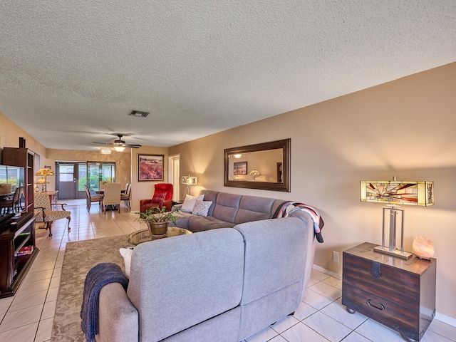 tiled living room with a textured ceiling and ceiling fan