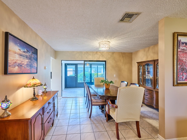 tiled dining space with a textured ceiling