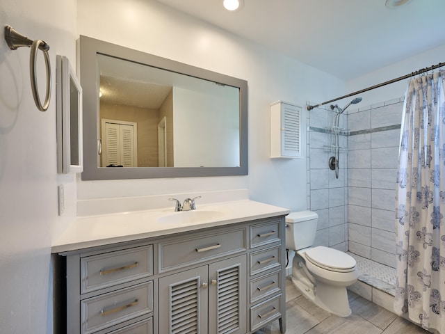 bathroom with curtained shower, vanity, and toilet