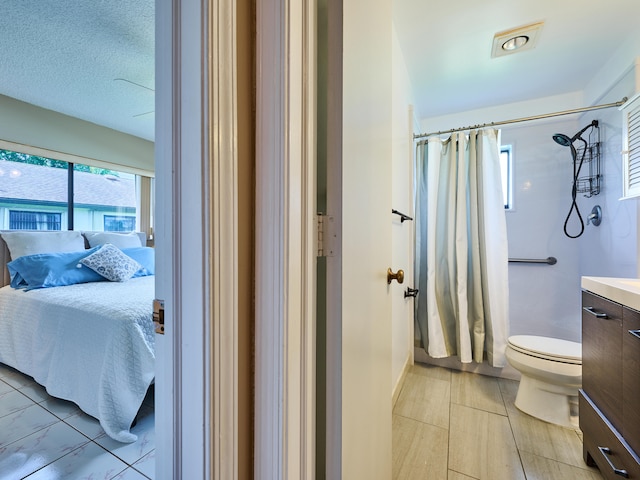 bathroom with curtained shower, vanity, and toilet