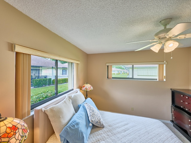 bedroom with multiple windows, a textured ceiling, and ceiling fan