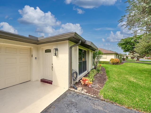 property entrance with a garage and a yard