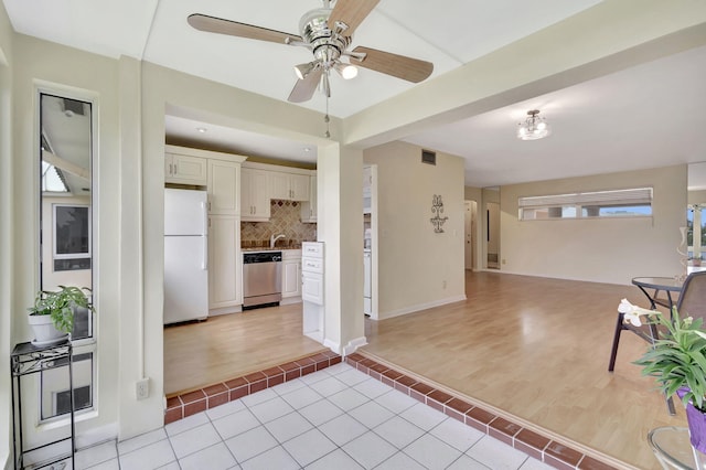 interior space featuring light hardwood / wood-style flooring, dishwasher, backsplash, and white refrigerator