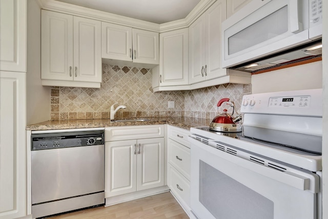 kitchen featuring tasteful backsplash, white cabinetry, light hardwood / wood-style flooring, sink, and white appliances