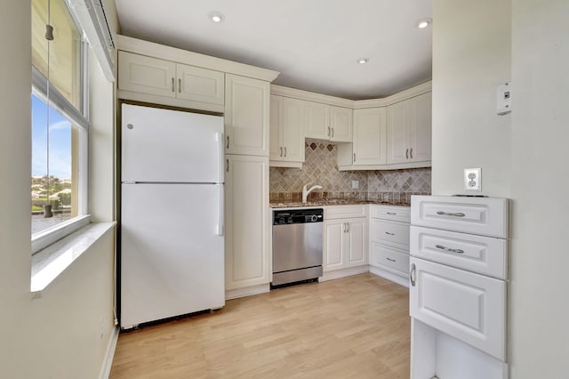 kitchen featuring decorative backsplash, white cabinets, light hardwood / wood-style flooring, dishwasher, and white fridge