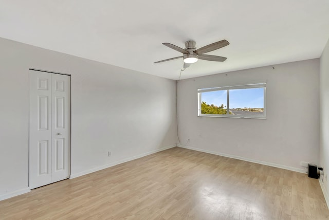 empty room with light hardwood / wood-style flooring and ceiling fan