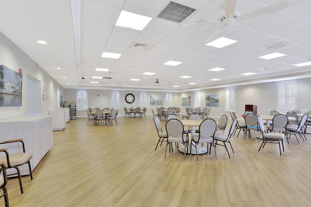 dining space with a drop ceiling, light hardwood / wood-style flooring, and ceiling fan