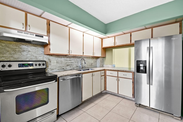 kitchen featuring light tile patterned flooring, white cabinetry, sink, and appliances with stainless steel finishes