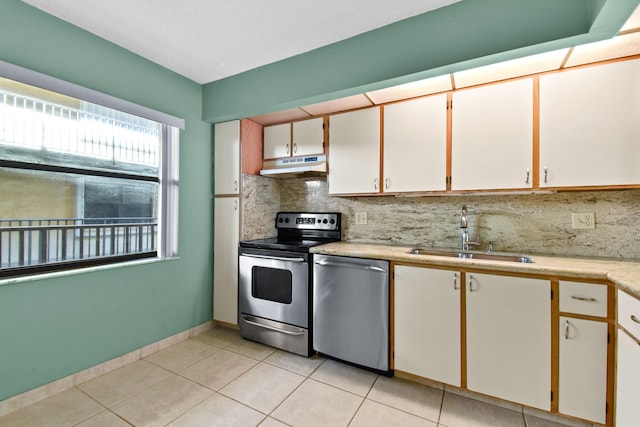 kitchen featuring stainless steel appliances, white cabinetry, sink, tasteful backsplash, and light tile patterned floors