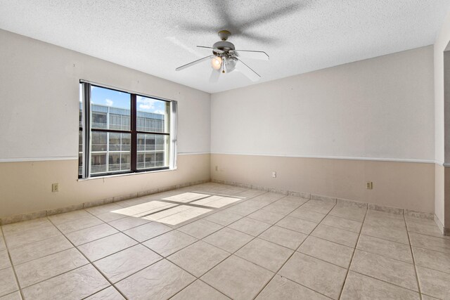 tiled bedroom with a textured ceiling and ceiling fan