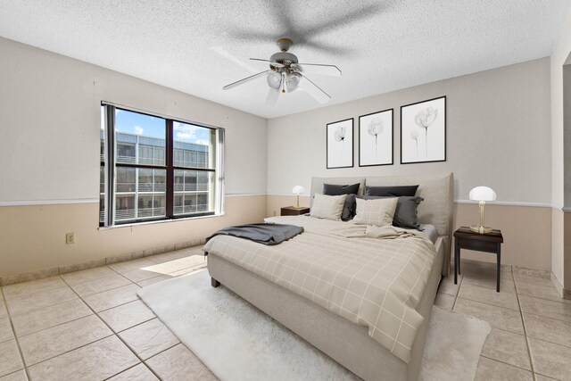 spare room with ceiling fan, a textured ceiling, and light tile patterned flooring