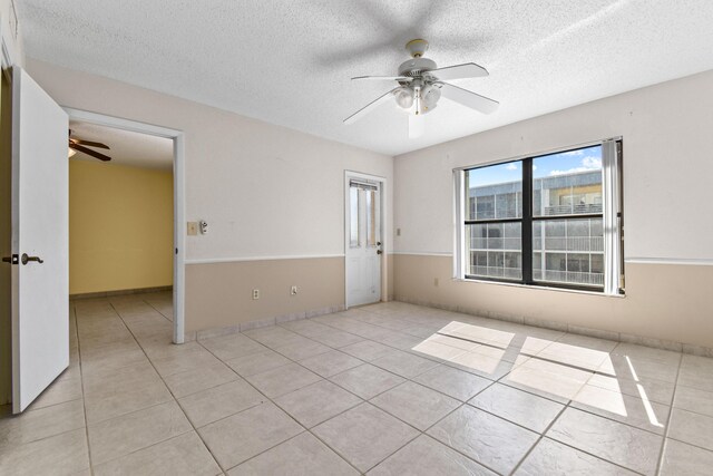 empty room featuring ceiling fan and light tile patterned floors