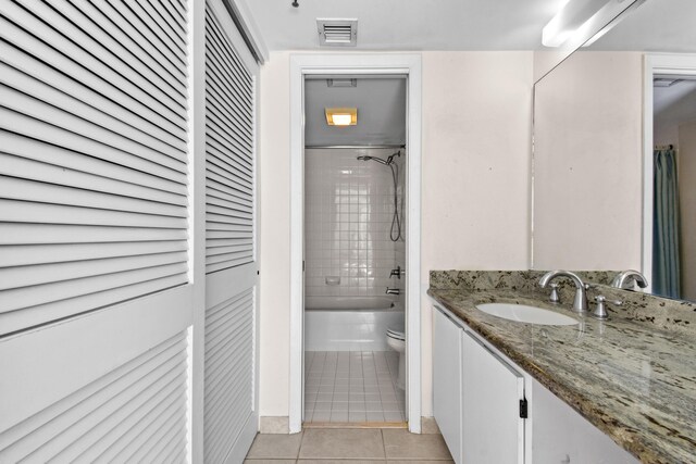 full bathroom with vanity, tile patterned floors, toilet, and tiled shower / bath