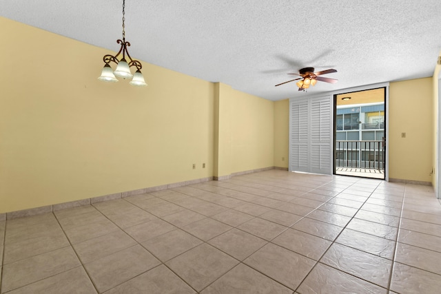 tiled spare room with ceiling fan with notable chandelier and a textured ceiling