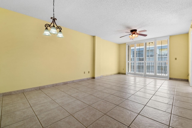 spare room with a textured ceiling, light tile patterned flooring, and ceiling fan with notable chandelier