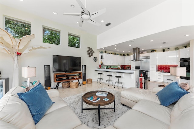 living room featuring ceiling fan and a towering ceiling