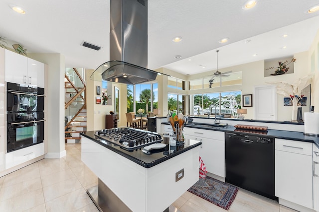 kitchen with island range hood, black appliances, white cabinets, and ceiling fan