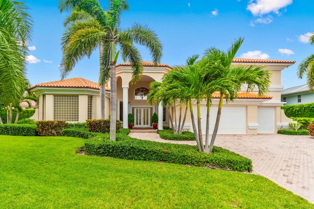 mediterranean / spanish-style house featuring a front lawn and a garage