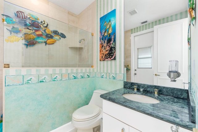 bathroom with vanity, a tile shower, and toilet