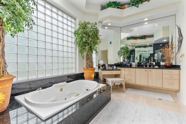 bathroom featuring vanity, tiled bath, and tile patterned flooring