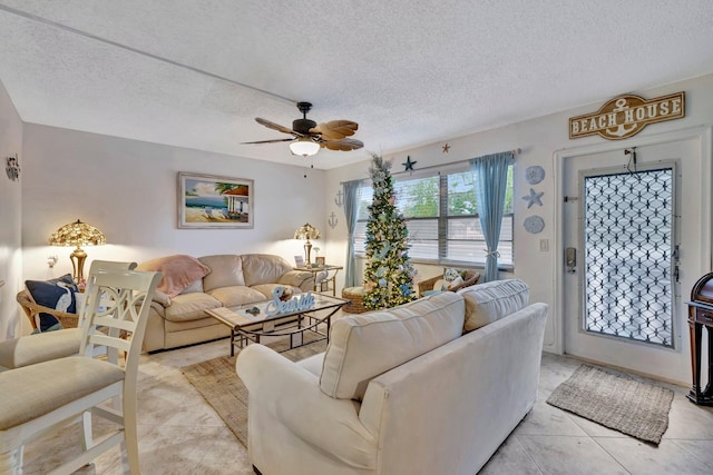 living room with a textured ceiling, light tile patterned floors, and ceiling fan