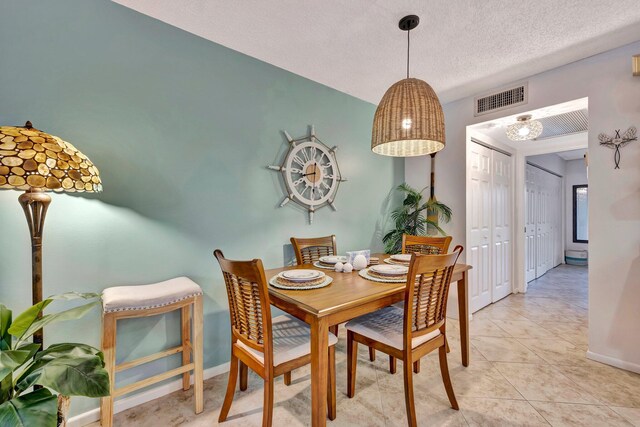 dining space with light tile patterned flooring and a textured ceiling